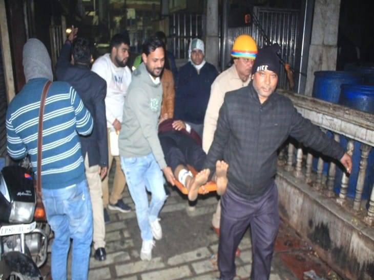 स्ट्रेचर से घायल व्यक्ति को एम्बुलेंस तक लाते सुरक्षाकर्मी।