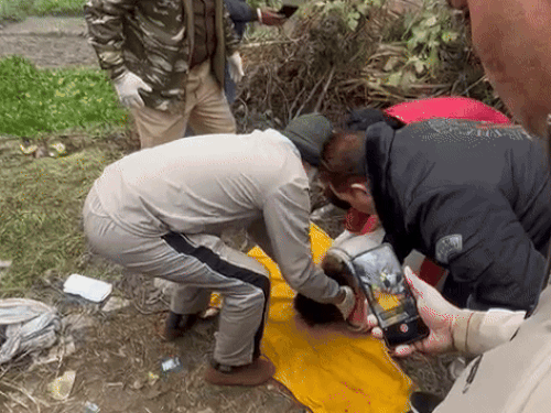 ड्रम से युवक का शव बाहर निकालती पुलिस।