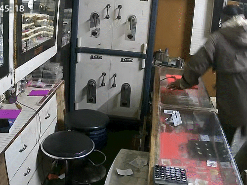 दुकान के अंदर घुसकर काउंटर के पास जाता बदमाश।