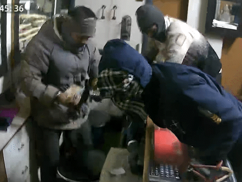 अपनी जैकेट में रुपए रखता हुआ बदमाश।