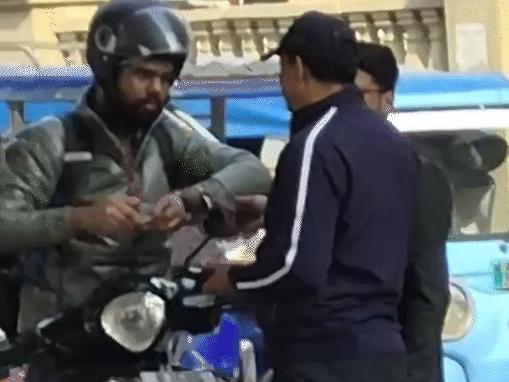 वीडियो में ट्रैफिक पुलिसकर्मी युवक से रुपए लेते नजर आ रहा है।