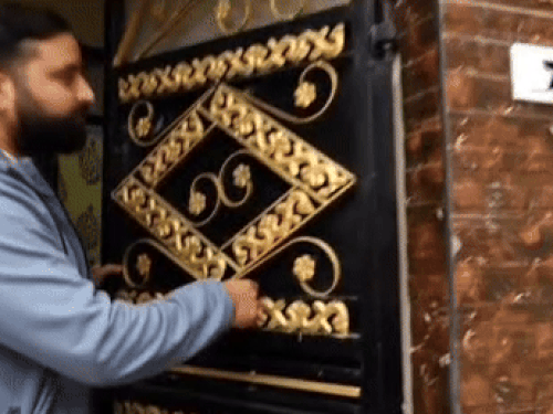 शाही मोहल्ला में गेट पर लगी गोलियों का निशान दिखाते पीड़ित।