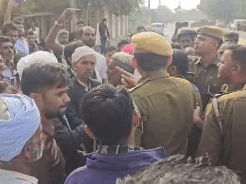 छात्र-छात्राओं के साथ प्रदर्शन करते ग्रामीणों को गिरफ्तारी के लिए धमकाती पुलिस।