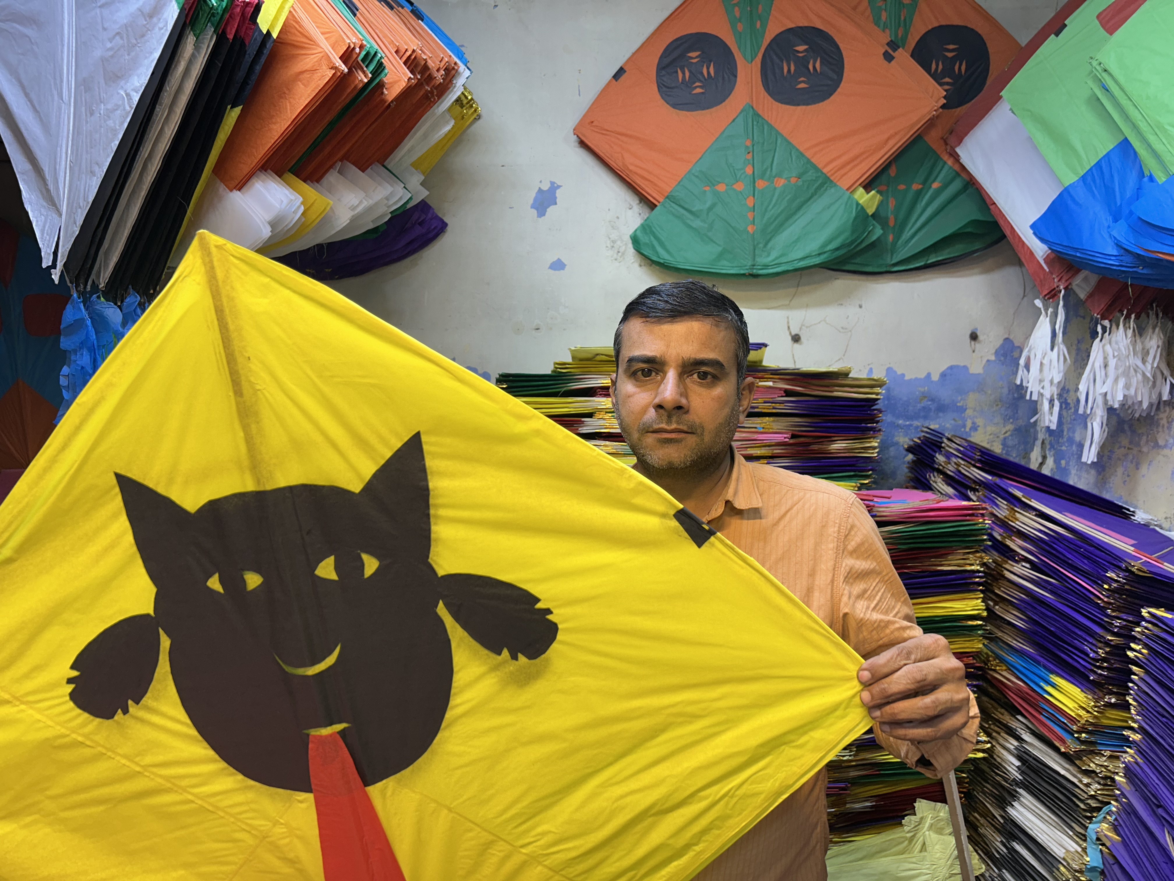 दुकानदार अजय पतंग दिखाते हुए