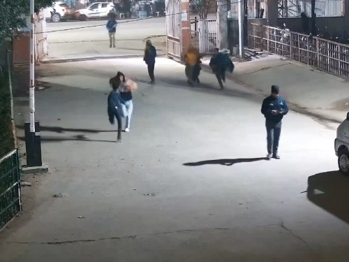 हाथ में हॉकी लेकर दौड़ते हुए।