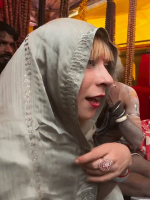 माघ मेले में इटली से आई 22 साल की लुक्रेशिया भारतीय परिधान में मंत्रोच्चारण सिख रही है।