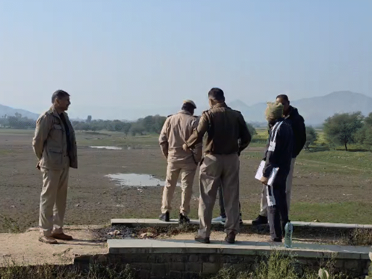 जयसमंद बांध के बीच रखी संदिग्ध वस्तु की निगरानी करते पुलिसकर्मी।