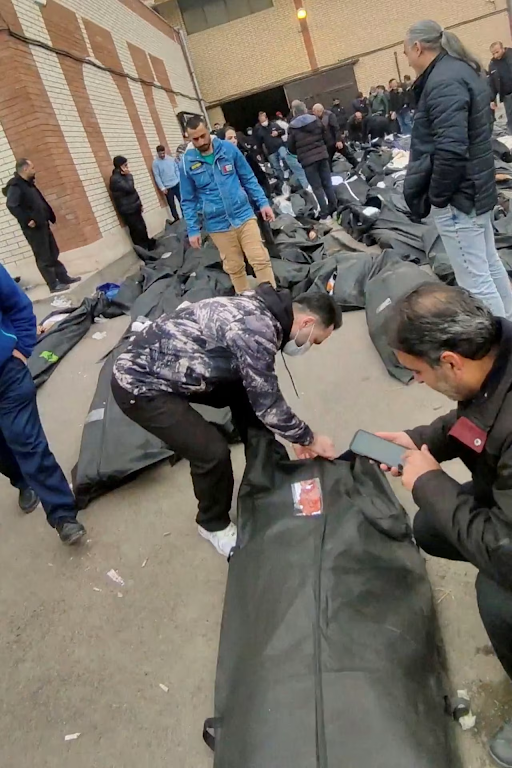 तेहरान में एक हॉस्पिटल की सामने पड़ी लाशों में से अपने परिवार वालों की पहचान करते लोग।