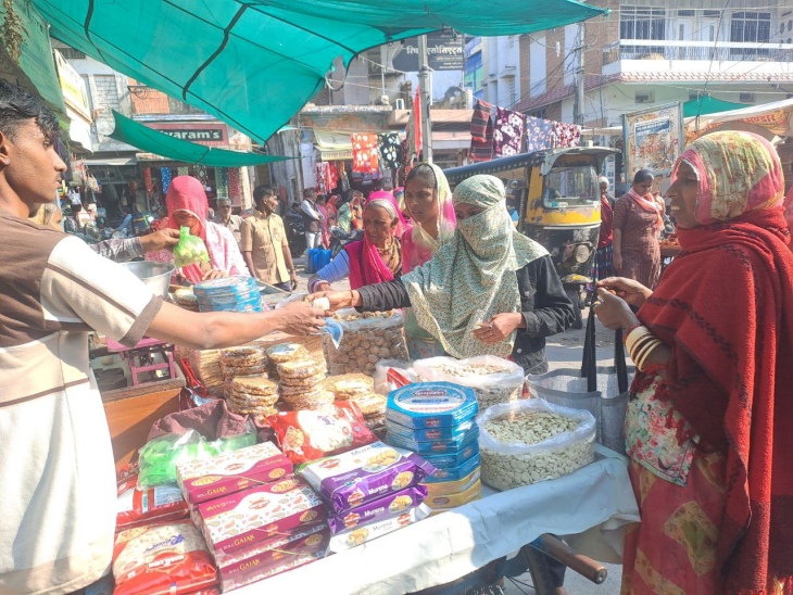पाली के धानमंडी बाजार में तिल से बने व्यंजन खरीदती महिलाएं।