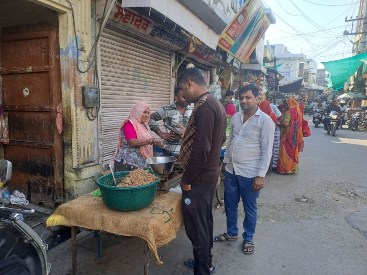 पाली के सूरजपोल-सोमनाथ रोड पर तिल से बने व्यंजन बेचती महिला।