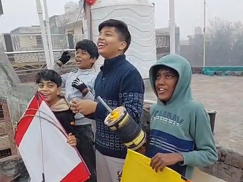 लोहड़ी पर छतों पर पतंग उड़ाते नौजवान।