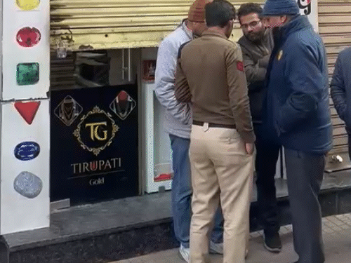 Police gather information from family members and local residents outside the jewellery shop at Gandhi Chowk.