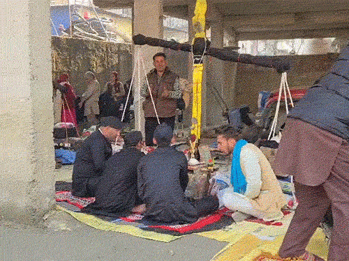 शिमला के तत्तापानी में तुलादान करवाते हुए लोग।