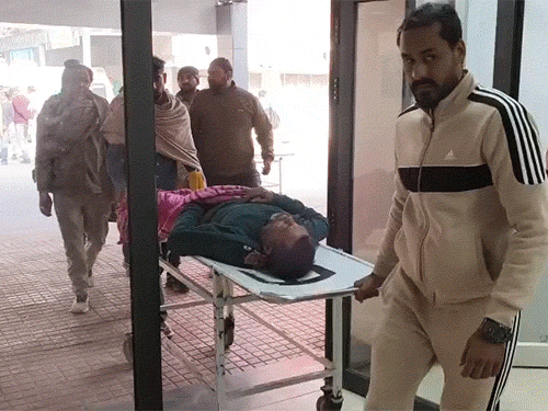 मरीजों को स्ट्रेचर पर लेटाकर अस्पताल के अंदर लाते लोग।