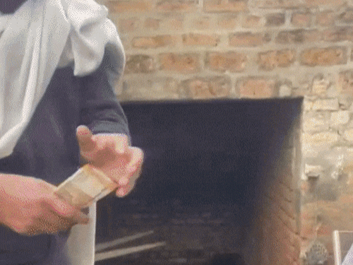 गोबर खाने से पहले युवक को एक हजार रुपए दिखाता दूसरा शख्स।