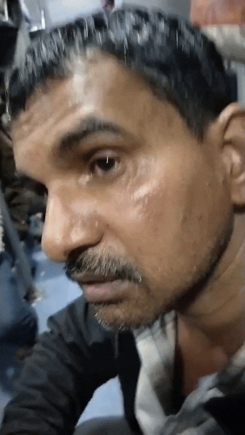 चोट के निशान दिखाते हुए ट्रेन में सवार यात्री।