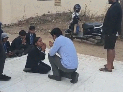 लेक्चरर के सामने बच्चे हाथ जोड़कर बैठे थे। इस पर उन्हें मनाने के लिए लेक्चरर घुटनों के बल बैठकर हाथ जोड़कर समझाने लगे।