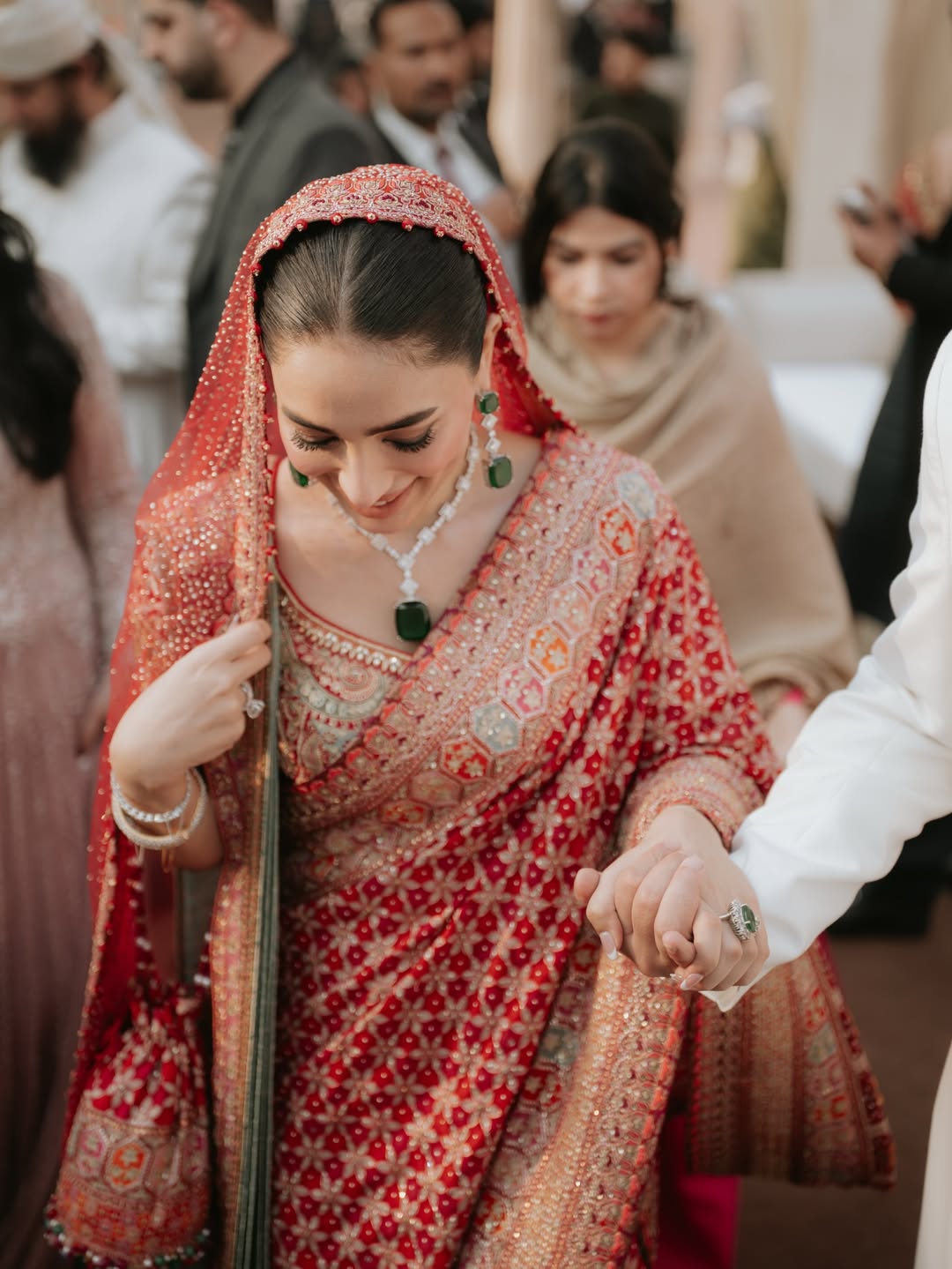 साड़ी के साथ पहना गया ग्रीन स्टोन नेकलेस, जो लाल रंग को खूबसूरती से कॉन्ट्रास्ट देता है। (इमेज क्रेडिट- सोशल मीडिया)