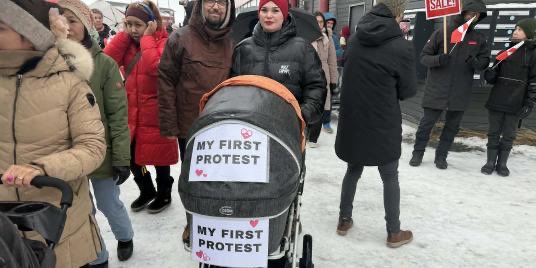 प्रदर्शन में लोग अपने नवजात बच्चों के साथ आए। एक बच्चे के स्ट्रोलर पर लिखा था- मेरा पहला प्रोटेस्ट।