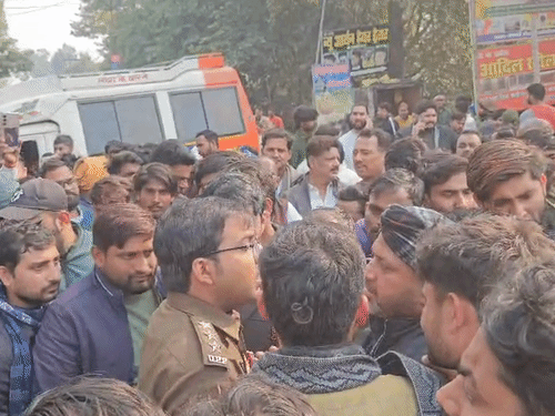 पुलिस अधिकारी लोगों को जाम हटाने के लिए समझा रहे हैं।