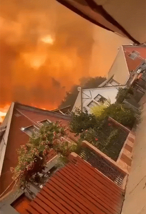 फुटेज में एक रिहायशी इलाके में घरों के पीछे आग जलती हुई नजर आ रही है।