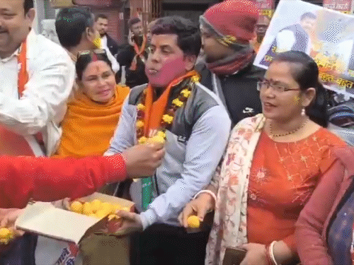 दिल्ली से ऐलान के बाद कार्यकर्ताओं ने एक दूसरे को मिठाई खिलाई।