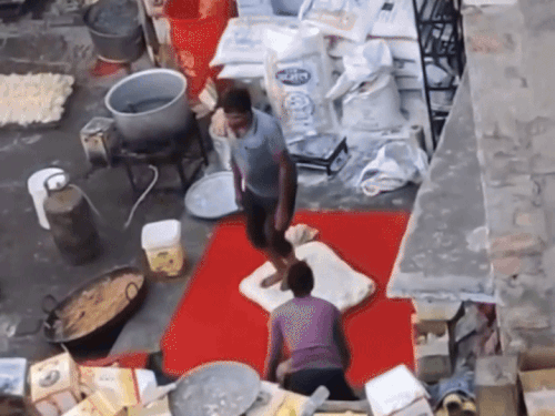 सालासर बालाजी फीणी उद्योग में पैरों से मैदा को गूंथता हलवाई।