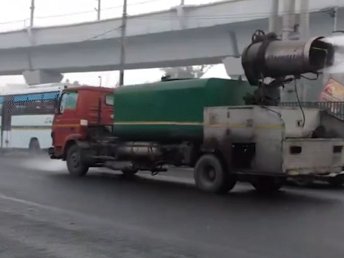 राजधानी दिल्ली में स्मॉग दोनों की मोटी परत छाई है। गुरुवार को प्रदूषण कम करने वाटर स्प्रेयर से छिड़काव हुआ।