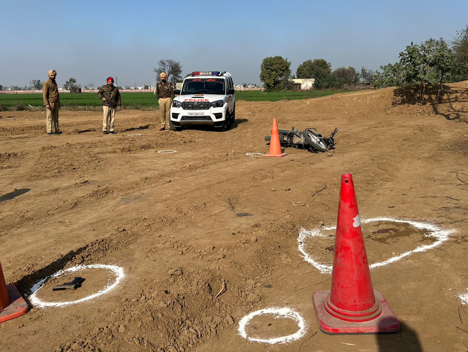 पटियाला में मुठभेड़ के बाद गिरी आरोपी की बाइक और वहां मौजूद पुलिस।