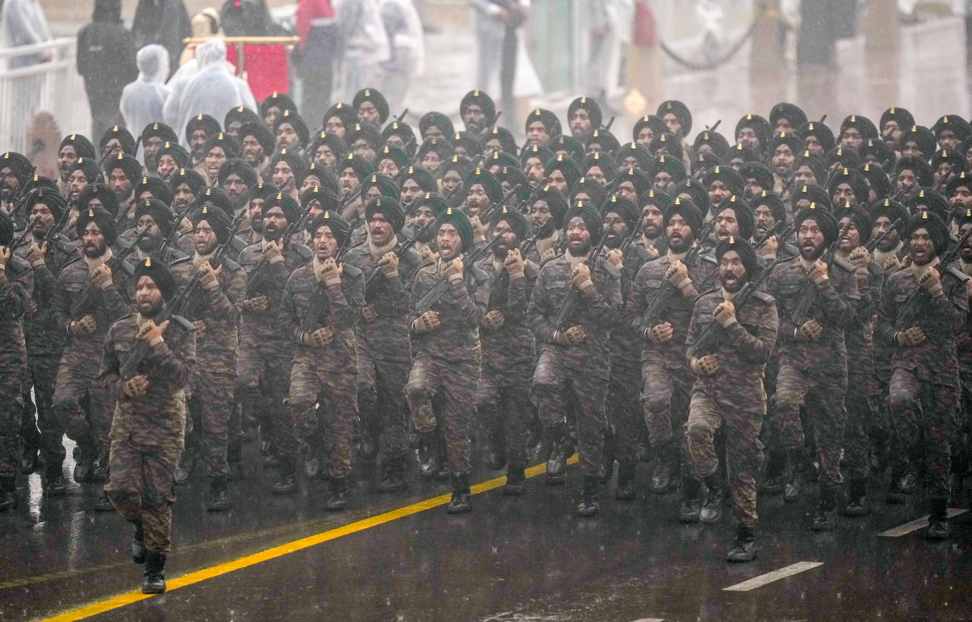 बारिश में भीगते हुए कर्तव्य पथ पर मार्च करते सिख रेजिमेंट के जवान।