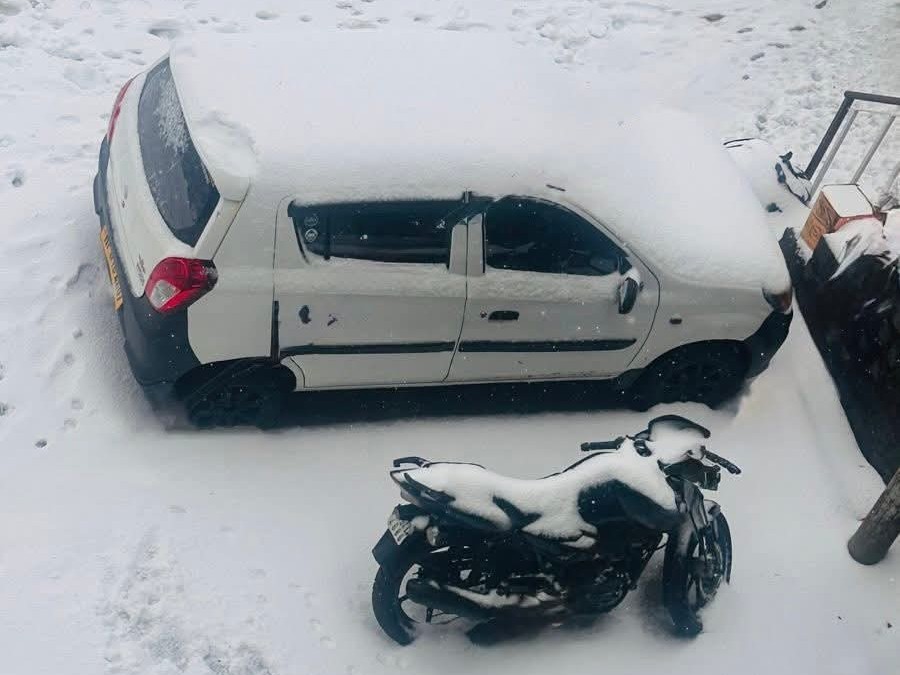 धर्मशाला में बर्फबारी के कारण कार और बाइक पर जमी बर्फ।