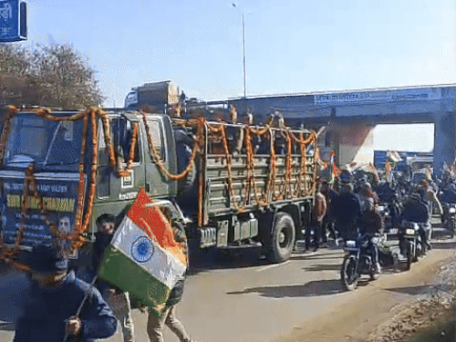 हाथों में तिरंगा लेकर शहीद जवान के सम्मान में रैली निकालते युवा।