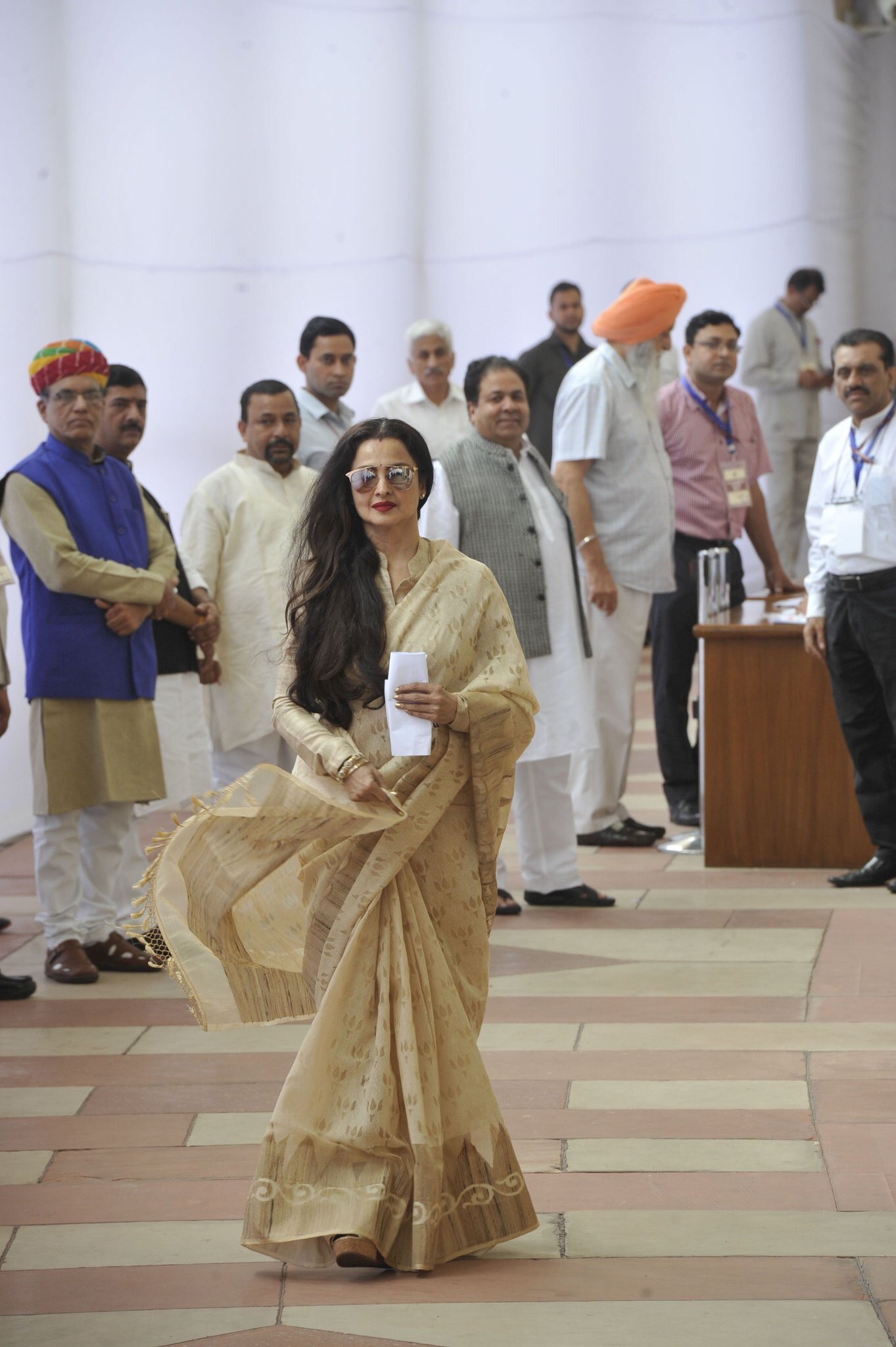 ફોટોમાં રેખાની પાછળ સફેદ કુર્તા-પાયજામા અને ગ્રે જેકેટમાં કોંગ્રેસ સાંસદ રાજીવ શુક્લા.