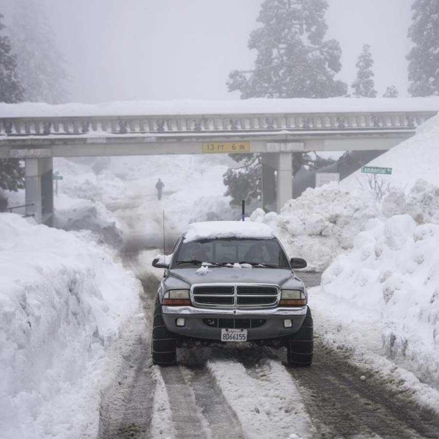 बर्फ से भरे रास्तों के बीच से गुजरती गाड़ी। सरकार ने गाड़ियों के इस्तेमाल को सीमित करने का निर्देश दिया है।