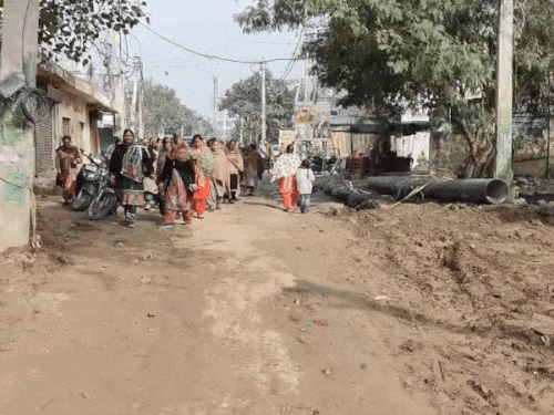 खराब सड़कों को दिखाती महिलाएं।