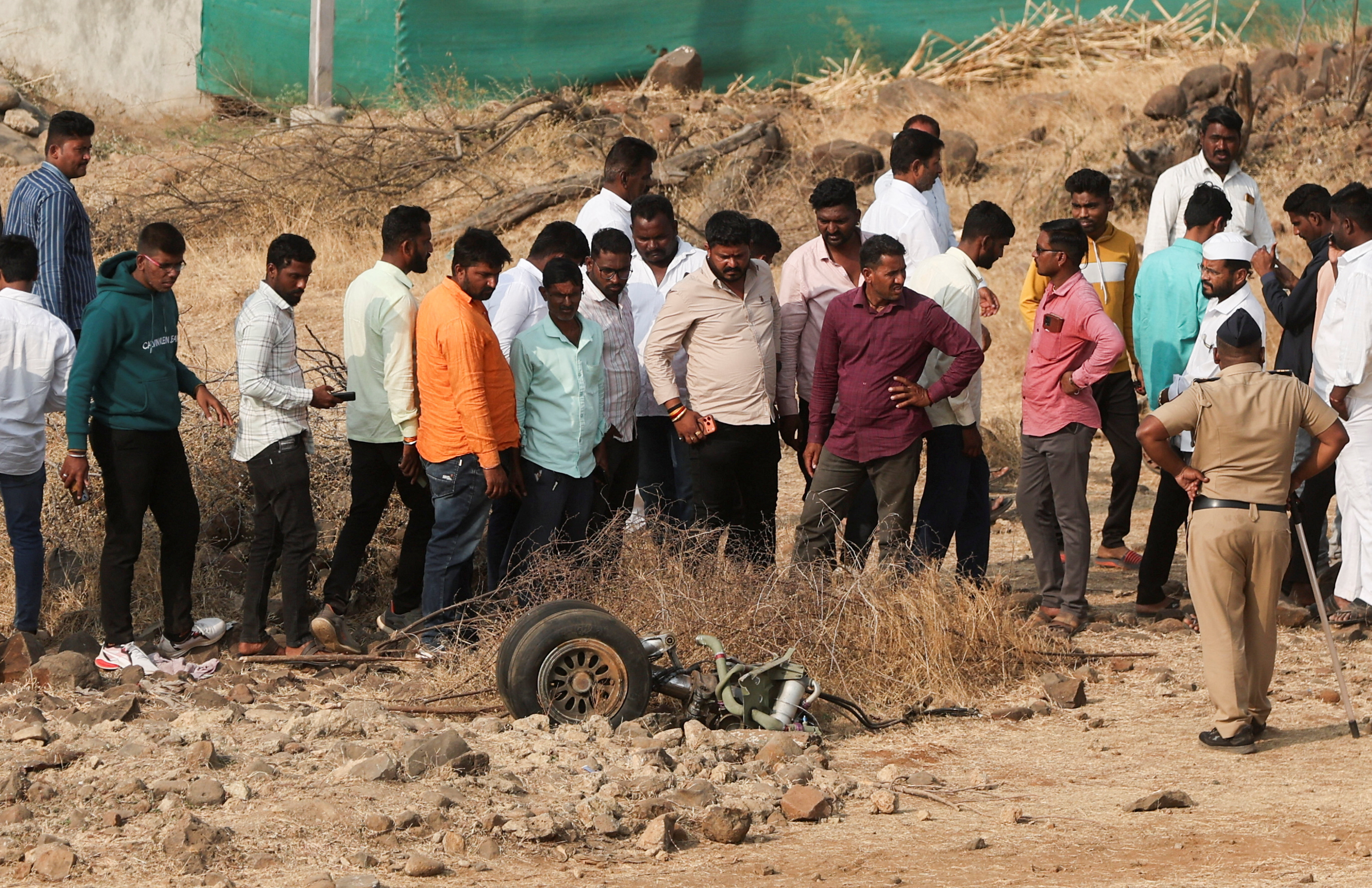प्लेन से पहियों को देखते ग्रामीण। लोगों ने कहा क्रैश के बाद 4-5 धमाके हुए।