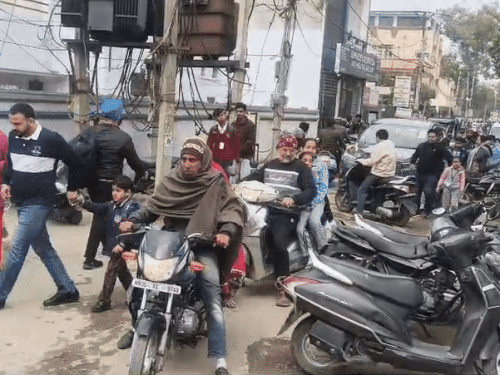 स्कूल से अपने बच्चों को लेकर जाते पेरेंट्स।