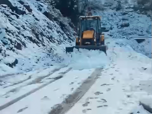 मंडी में कमांड-कटौला सड़क से बर्फ हटाते हुए जेसीबी।