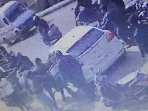 युवक का किडनैप कर कार में लेकर जाते बदमाश। वहीं मौके पर जमा भीड़। भीड़भाड़ वाले इलाके में ऐसी घटना से लोगों में गुस्सा है।