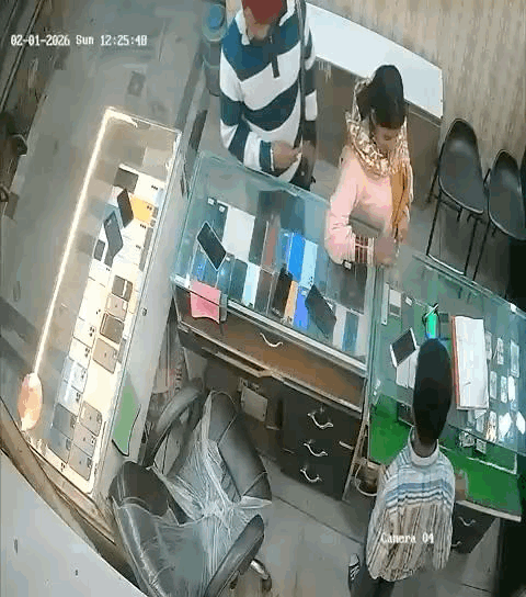 दुकान में मोबाइल देखते हुए