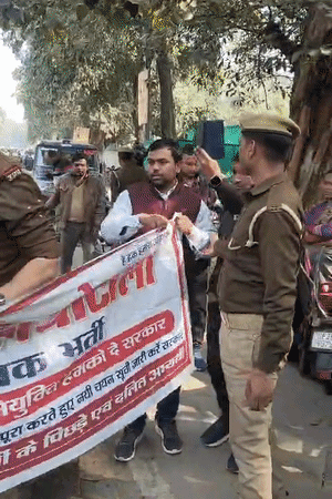 एक पुलिस अधिकारी ने अभ्यर्थियों का बैनर फाड़ दिया।