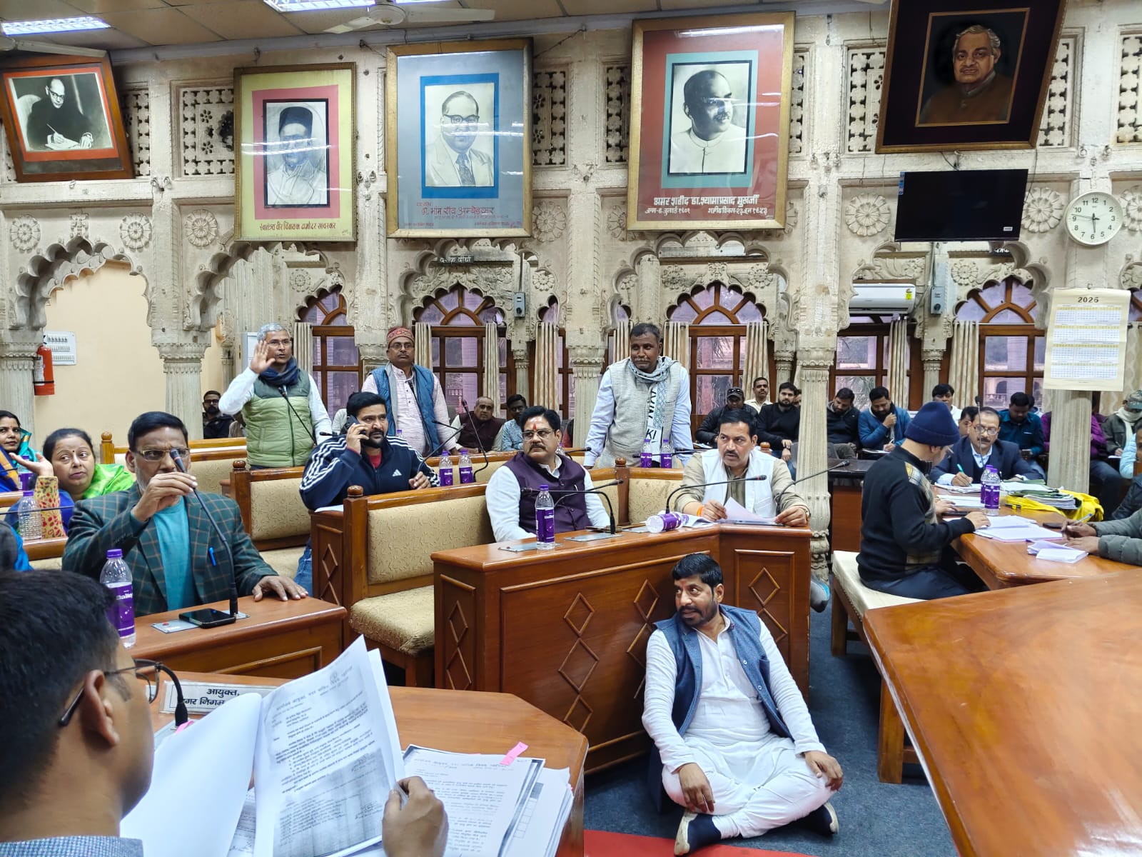 सभापति की कुर्सी के सामने धरने पर बैठे पार्षद।