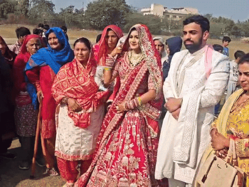 हेलिकॉप्टर में आई दुल्हन को देखने के लिए ग्रामीणों की भीड़ उमड़ी।