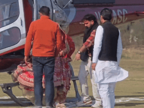 गुरुग्राम के कादीपुर गांव में हेलिकॉप्टर से उतरते दूल्हा गौरव और दुल्हन निधि।
