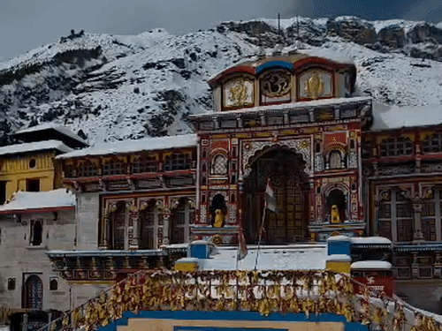 बीते दिनों हुई बर्फबारी के बाद बर्फ से ढंका बद्रीनाथ धाम।