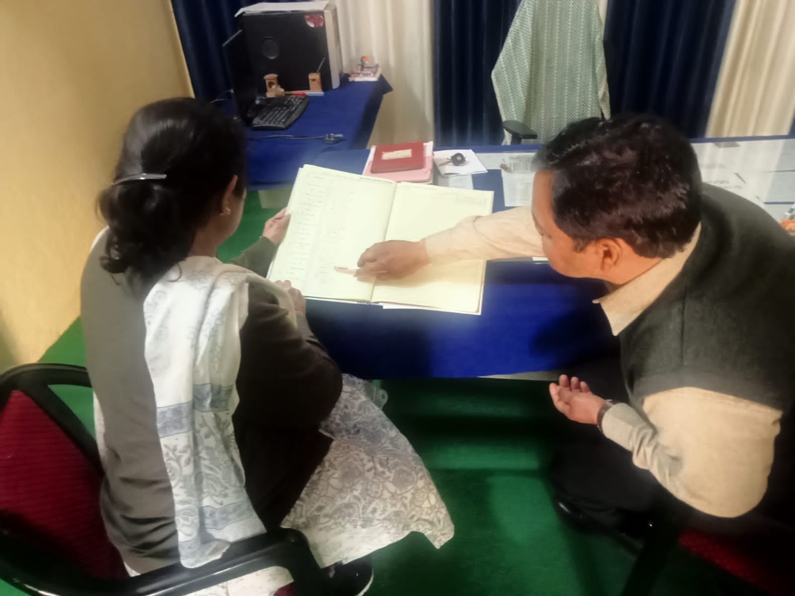 सचिव ने कार्मिक उपस्थिति पंजीका का मिलान किया।