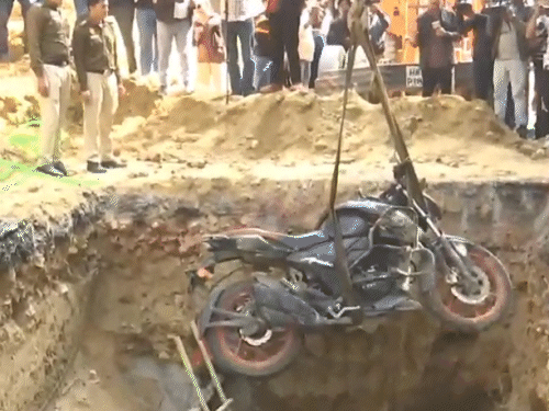 पुलिस ने शुक्रवार दोपहर को गड्ढे से बाइक निकलवाई।