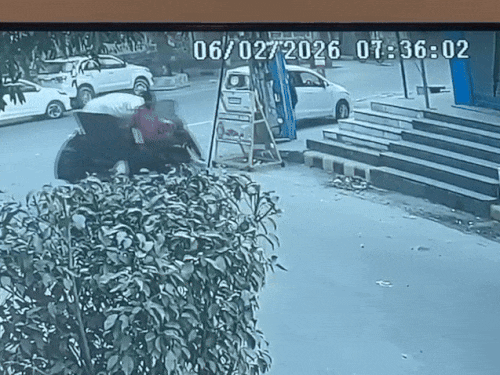 स्कूटी से उतरकर कार के पास टहलता युवक।