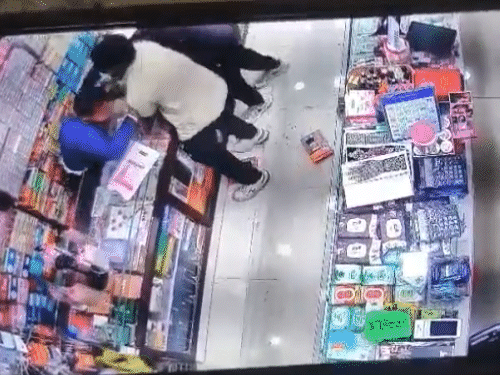 बचने के लिए दुकानदार नीचे बैठा तो दोनों बदमाश उसे बाहर खींचने लगे।