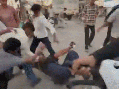 युवक छात्र को जमीन पर गिराकर लात-घूंसों से पीटते दिखे।